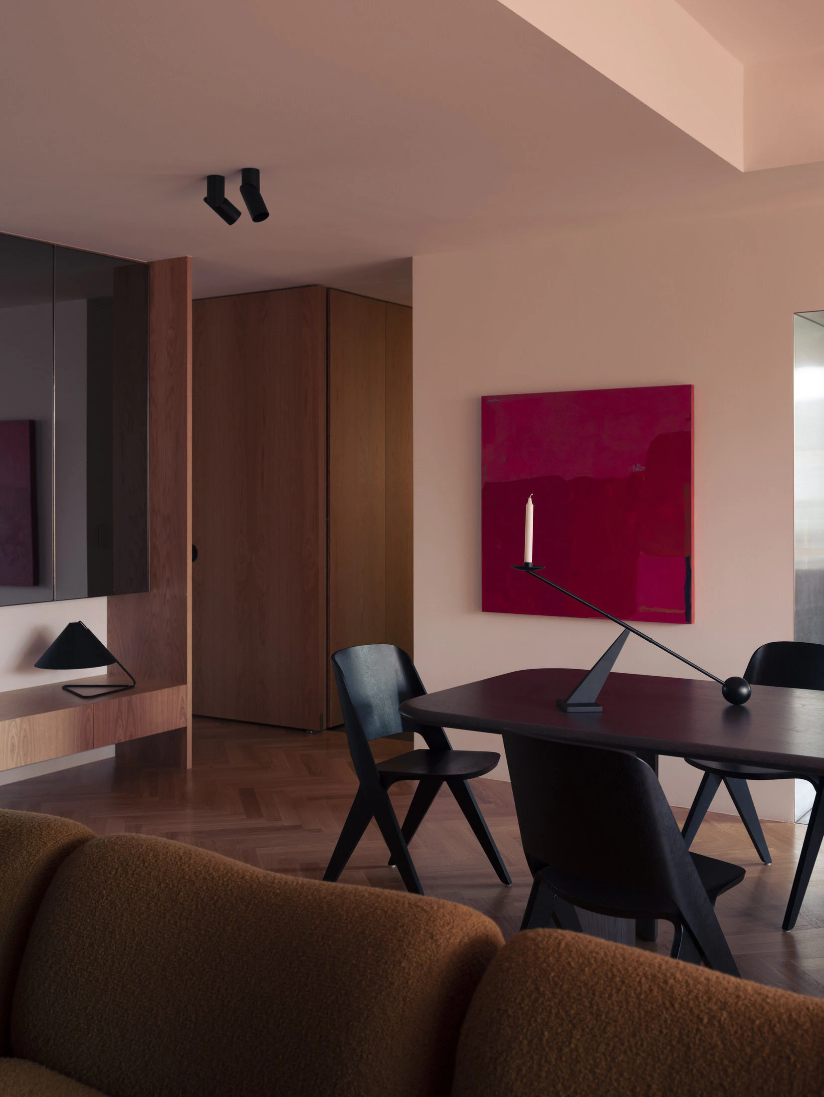 Contemporary living room with dark dining set and red artwork