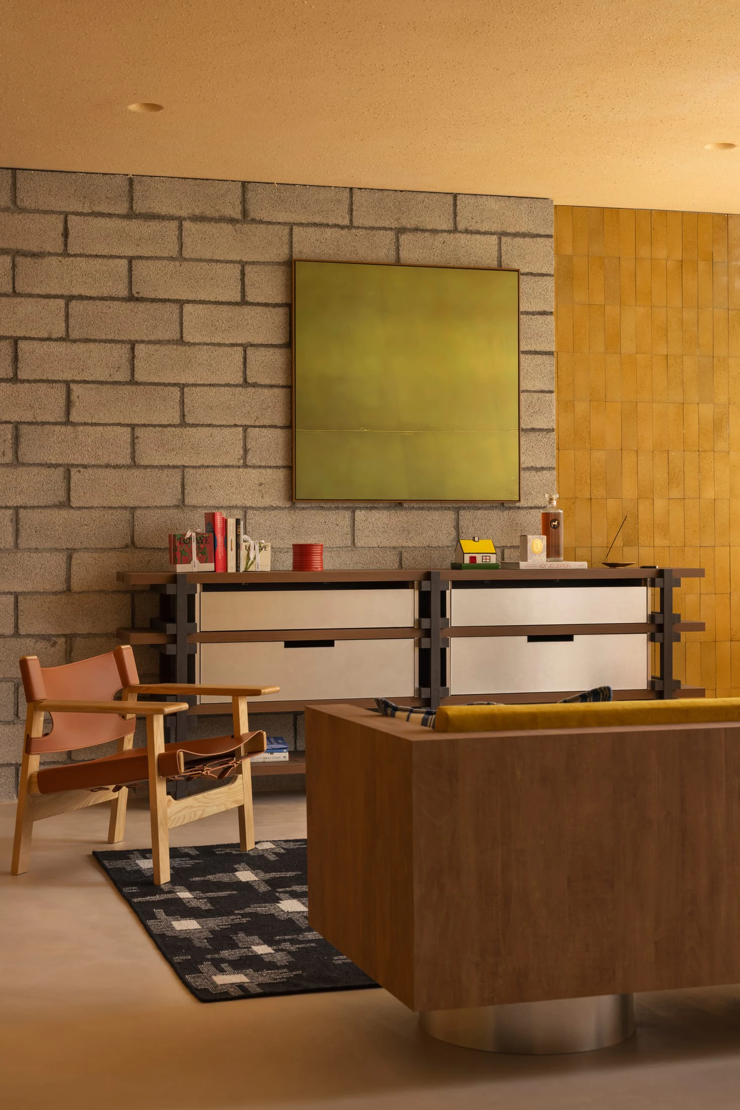 Mid-century living space with cinder block wall and leather chair