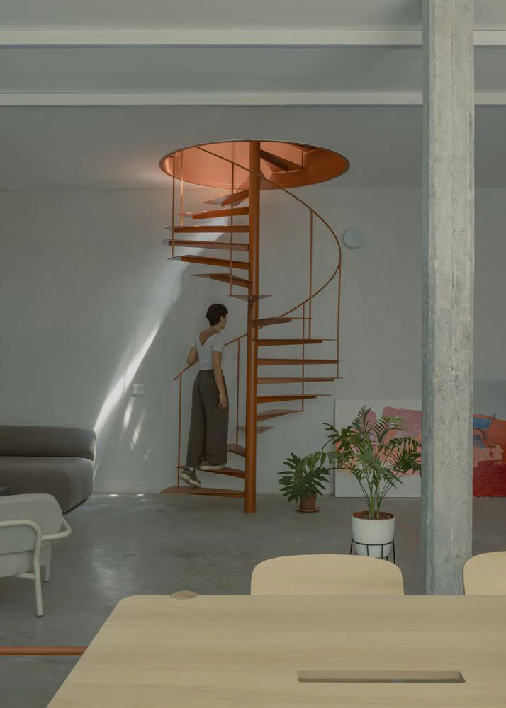 Industrial loft with copper spiral staircase and concrete floor